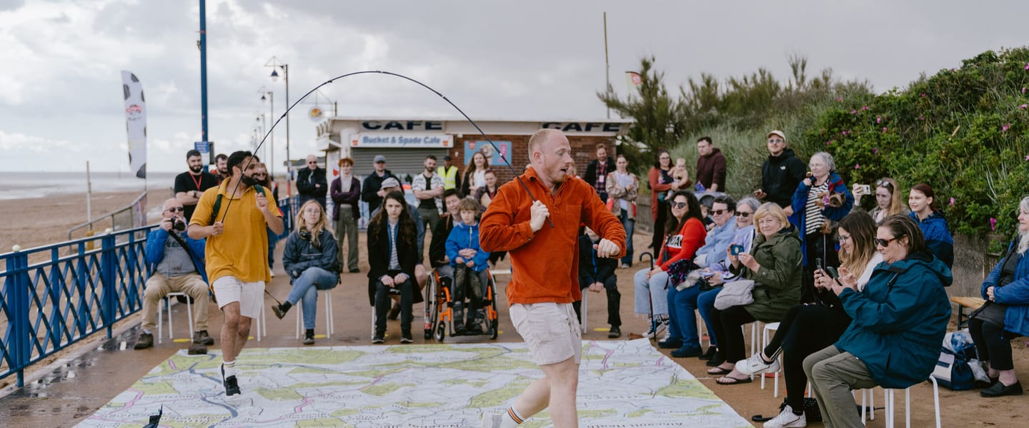 Two men are running on a large map in front of an audience