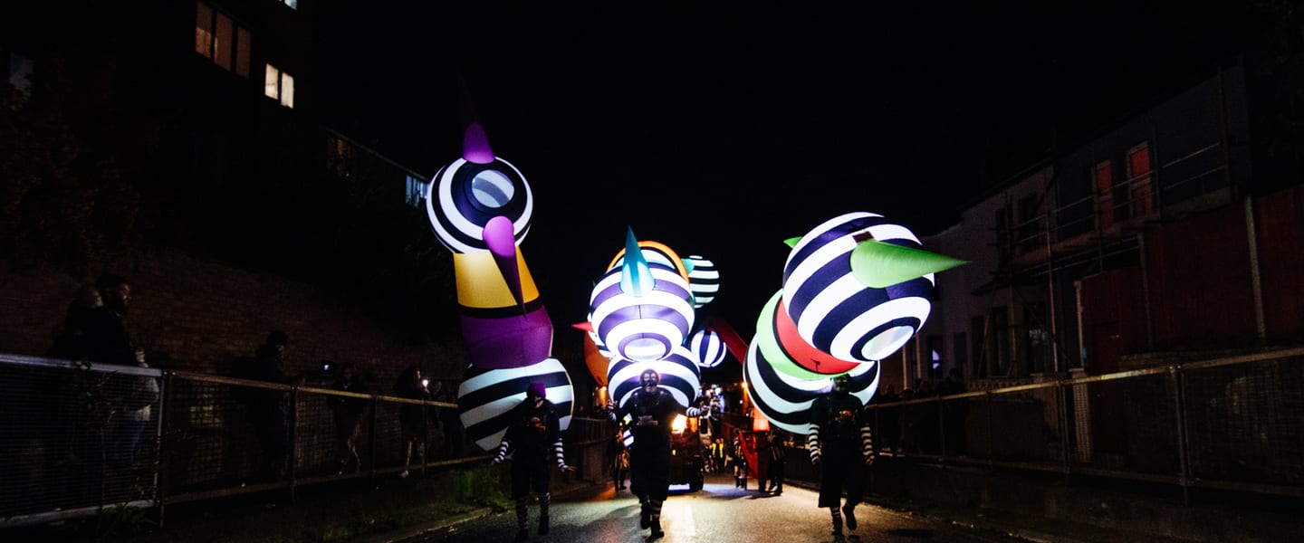Photograph shows glowing shapes with people silhouetted beneath